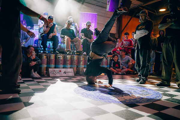 Professional picture of our male breakdancer performing head spin in front of other breakdancers for corporate conferences | Altus Entertainment